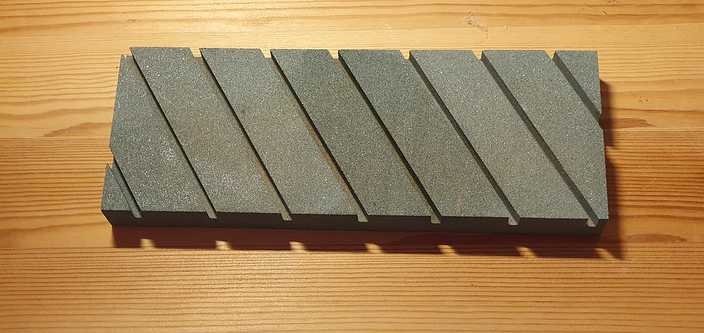 A ceramic dressing stone with drainage trenches for the grinding mud
